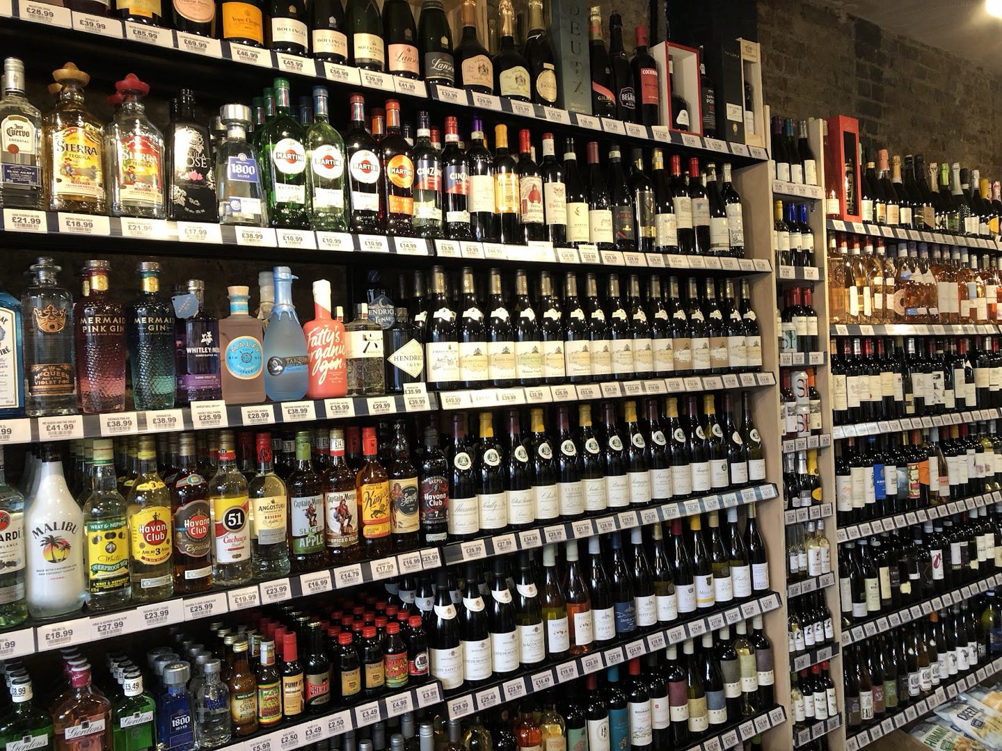 The wall of wine and spirits at Vintage Bottle, Lower Clapton, hundreds of bottles floor to ceiling with shelf-edge prices
